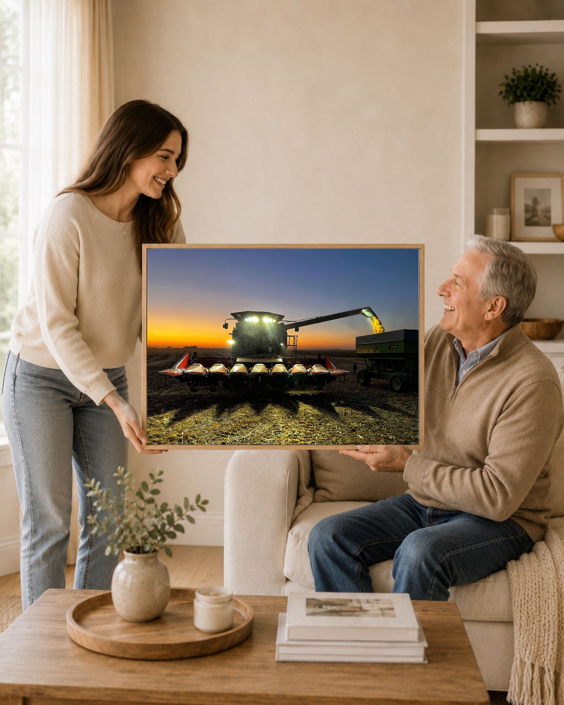 Woman gifting a framed combine harvest sunset canvas print to an older man in a warm farmhouse living room.
