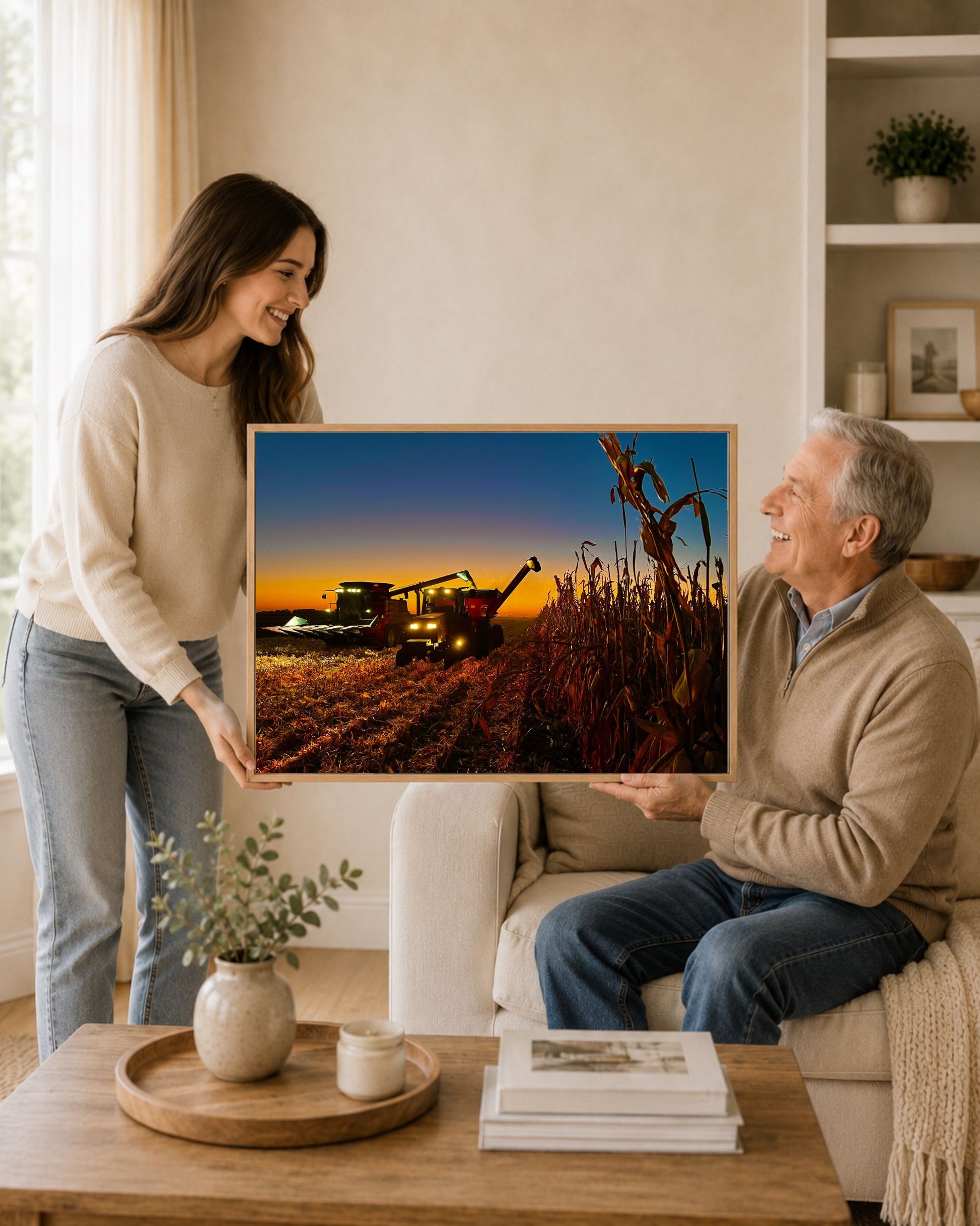 Woman gifting an oak framed corn harvest canvas print to an older man in a warm neutral living room.
