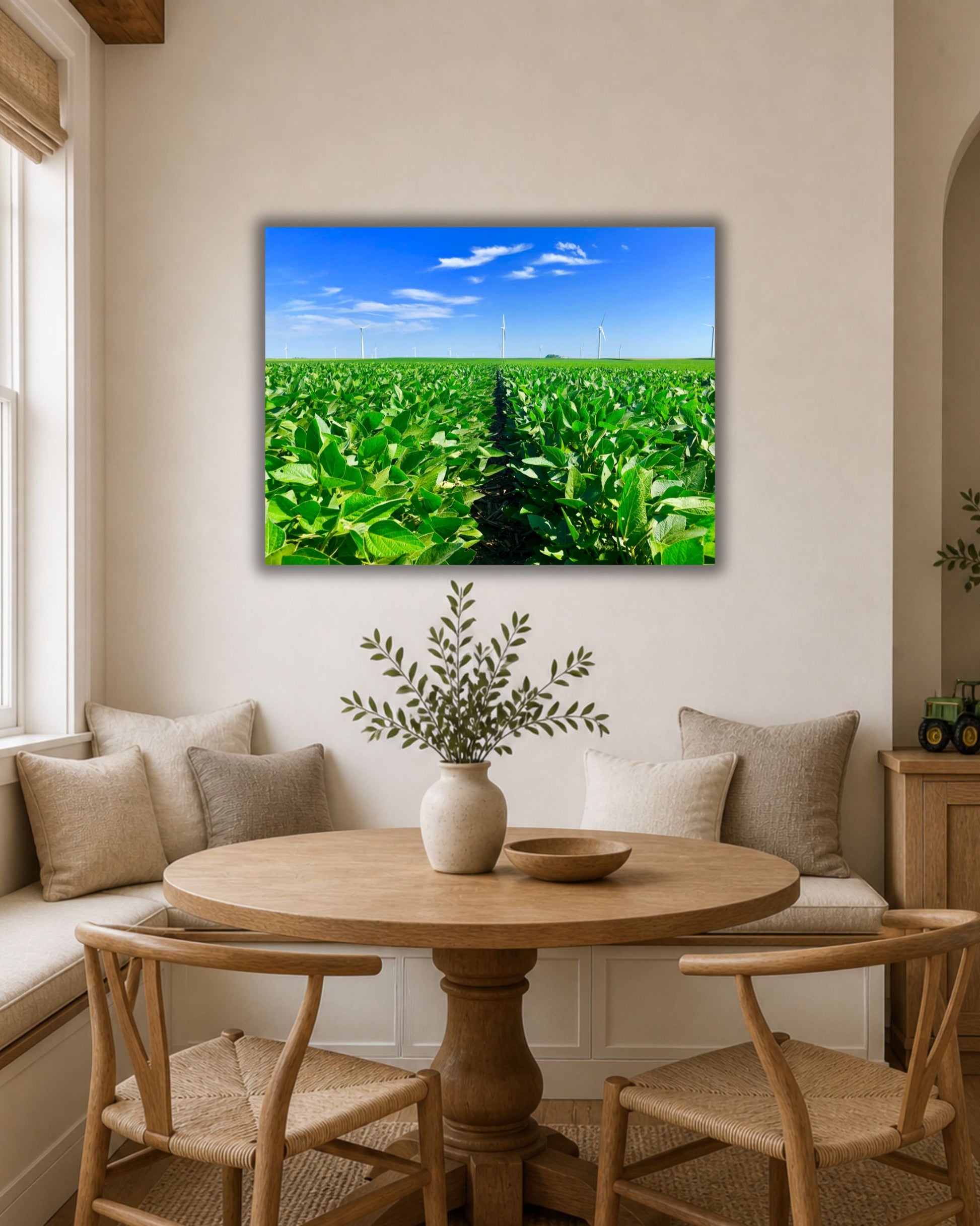 Canvas wall art of a lush green Iowa soybean field with wind turbines displayed above a farmhouse breakfast nook table.