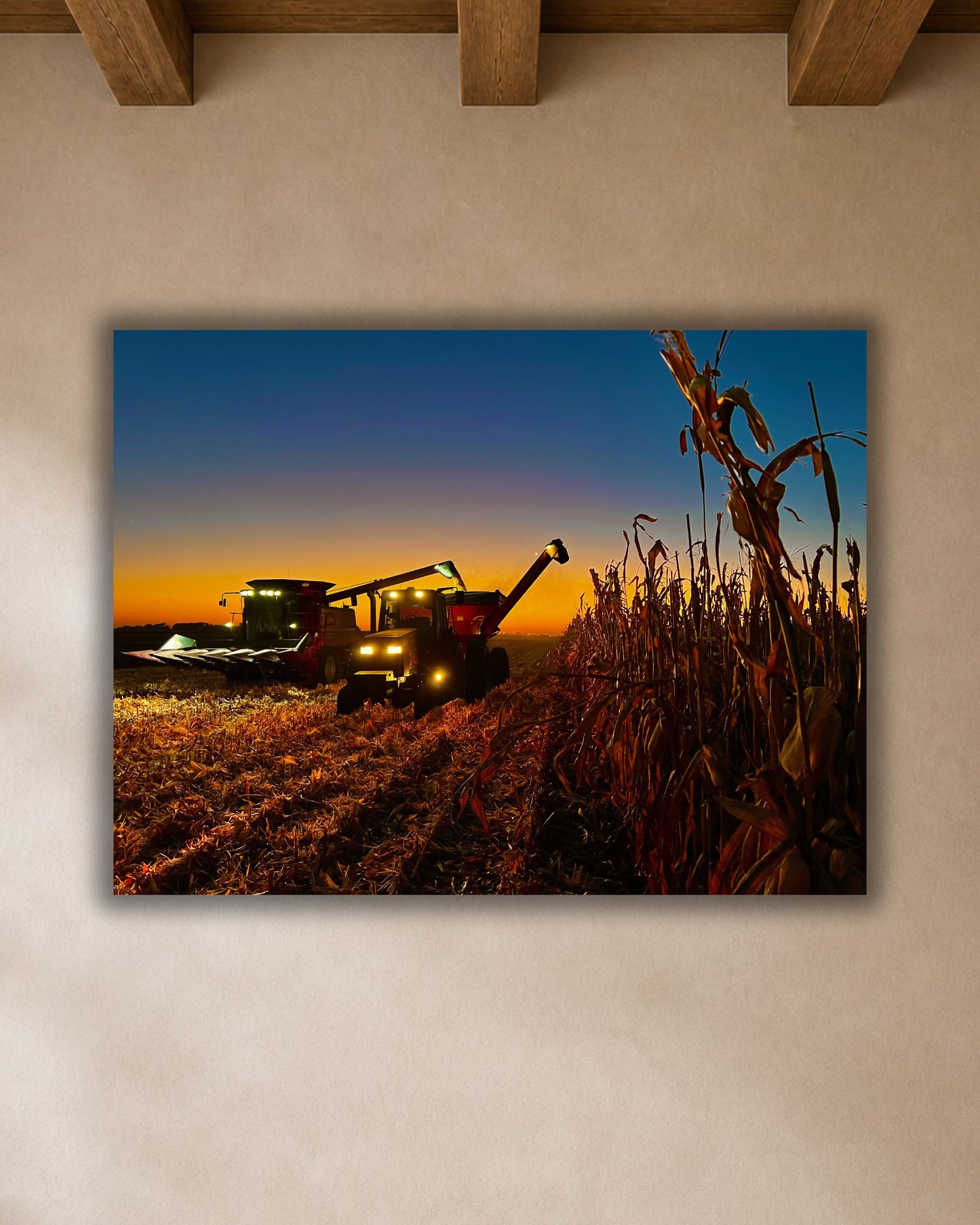 Close-up of corn harvest canvas print showing a combine and grain cart working beside standing corn at sundown.