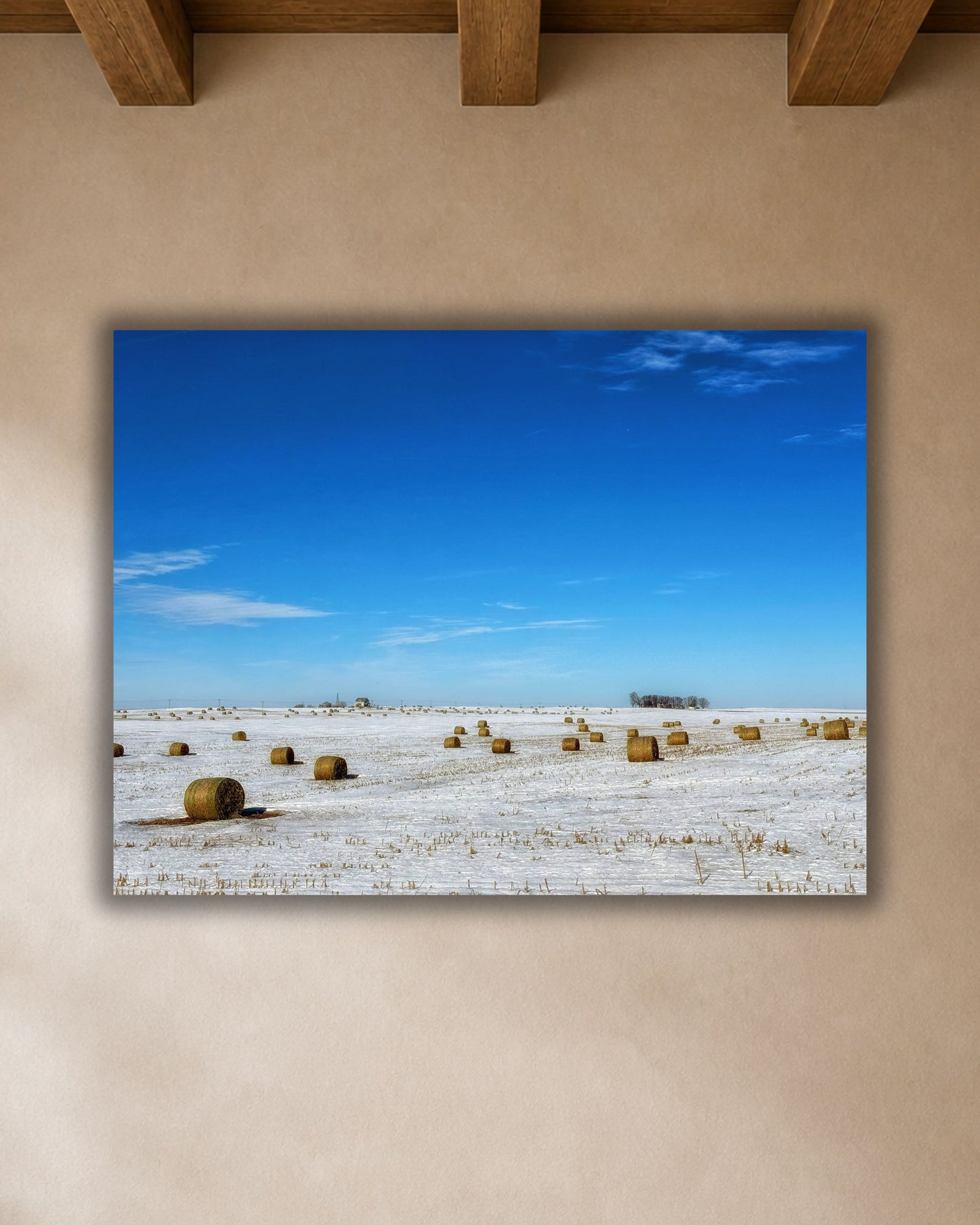 Close-up of winter hay bale canvas print showing a snow-covered Iowa field beneath a vivid blue sky.