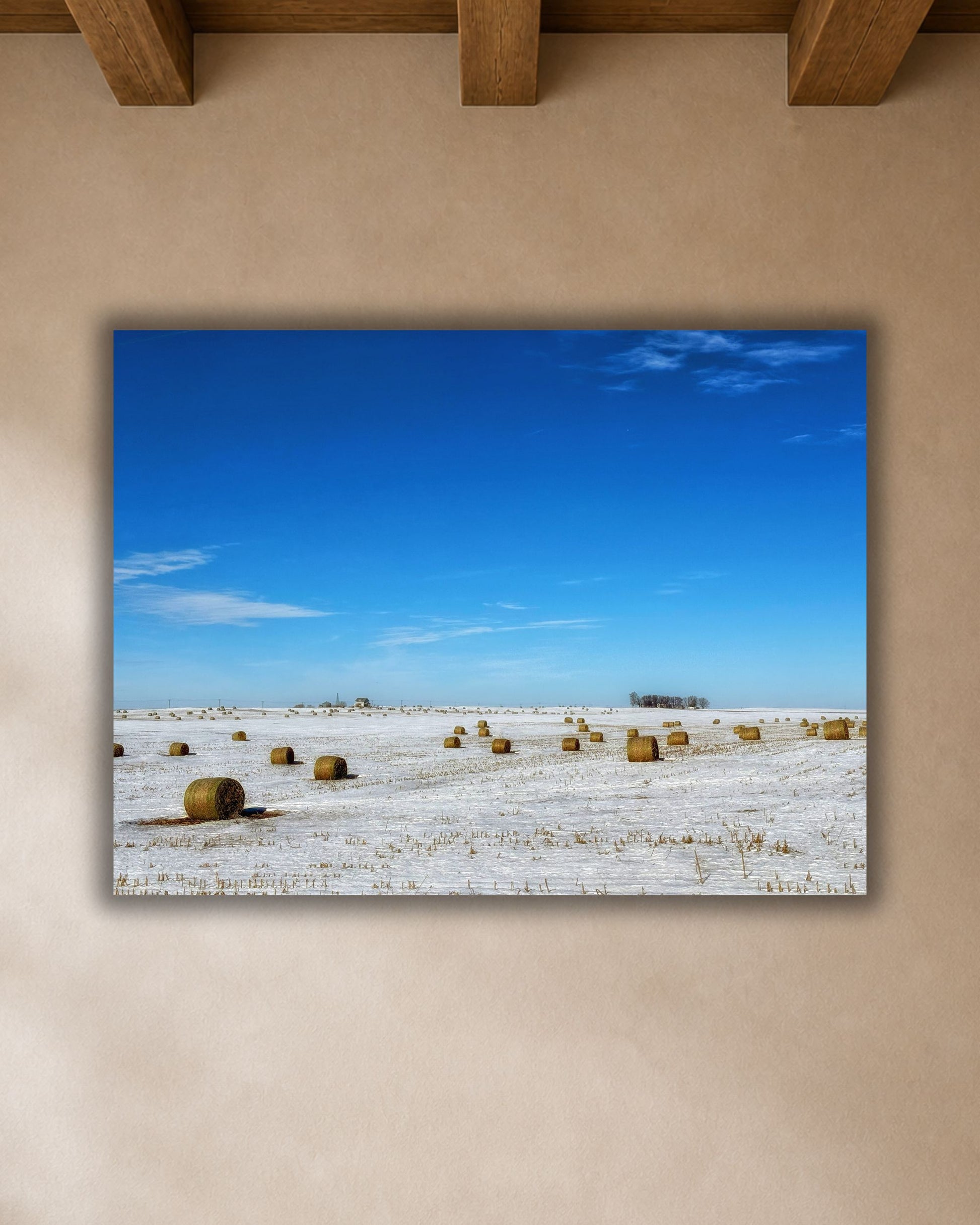 Close-up of winter hay bale canvas print showing a snow-covered Iowa field beneath a vivid blue sky.
