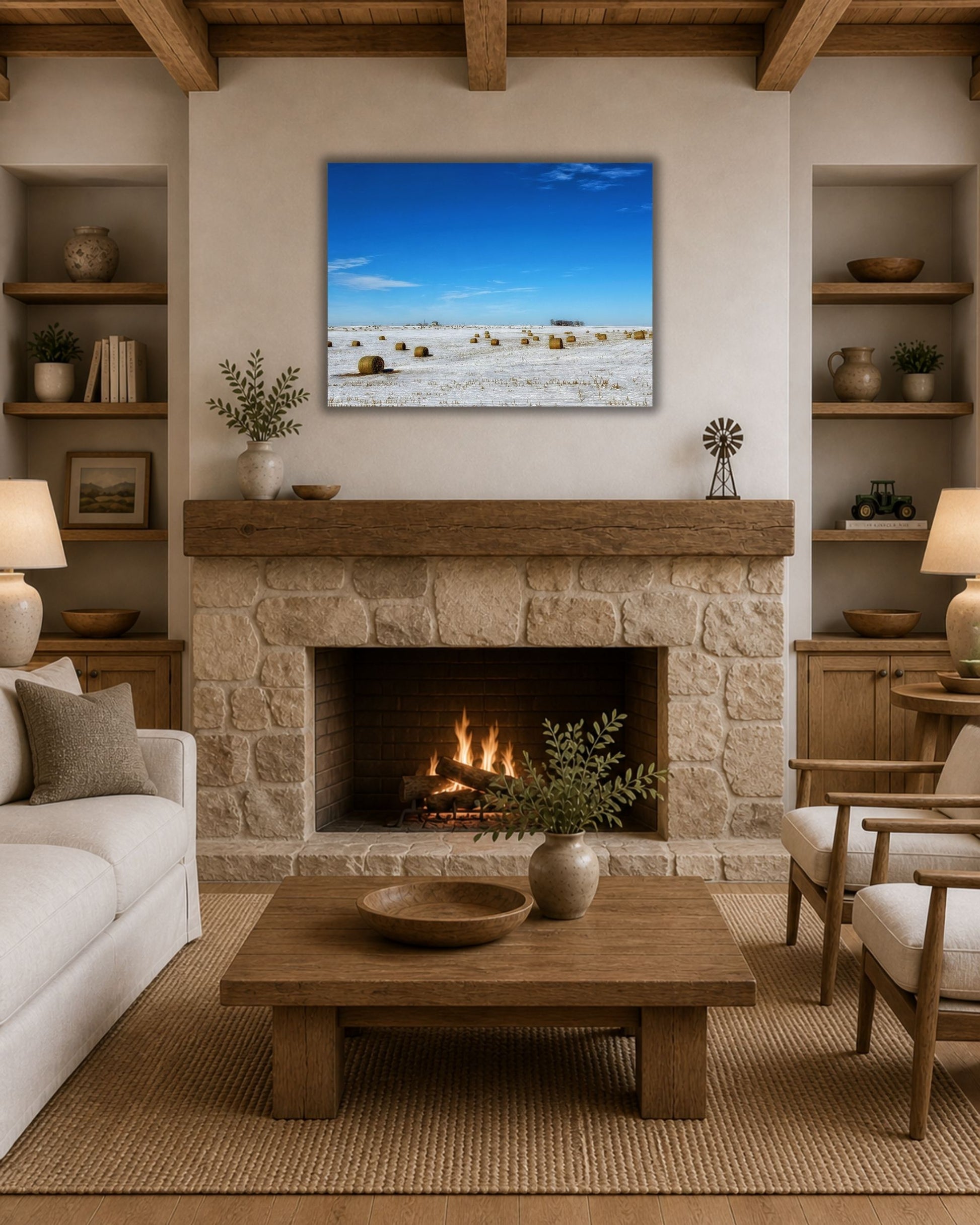 Snowy rural landscape canvas wall art styled above a stone fireplace in a cozy modern farmhouse living room.