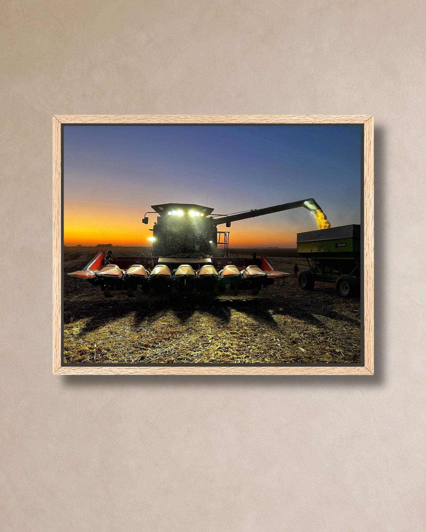 Gallery-wrapped canvas print of a combine unloading corn into a grain cart during an Iowa sunset harvest.