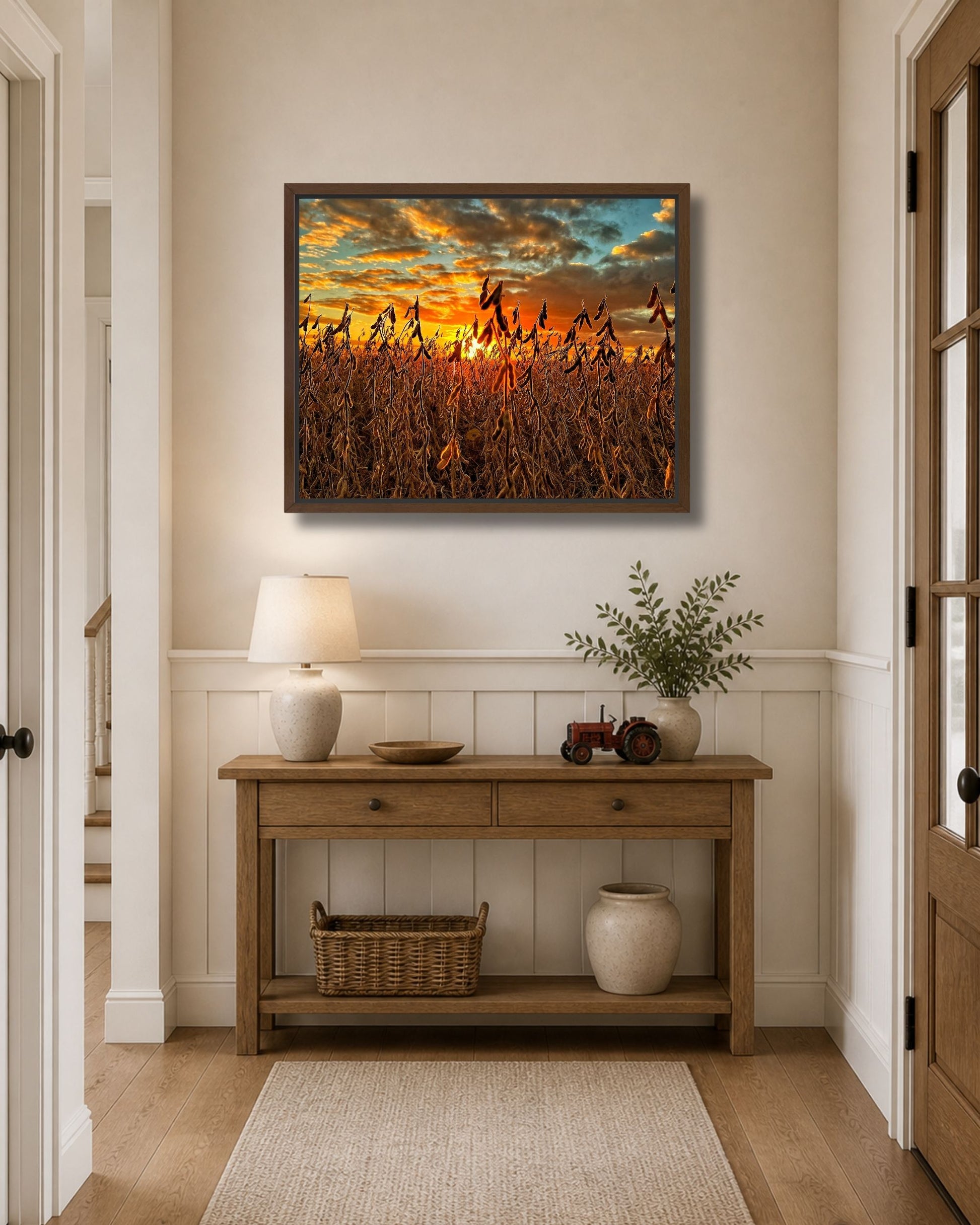 Walnut framed soybean field sunset canvas wall art displayed above a wood console table in a bright farmhouse entryway.