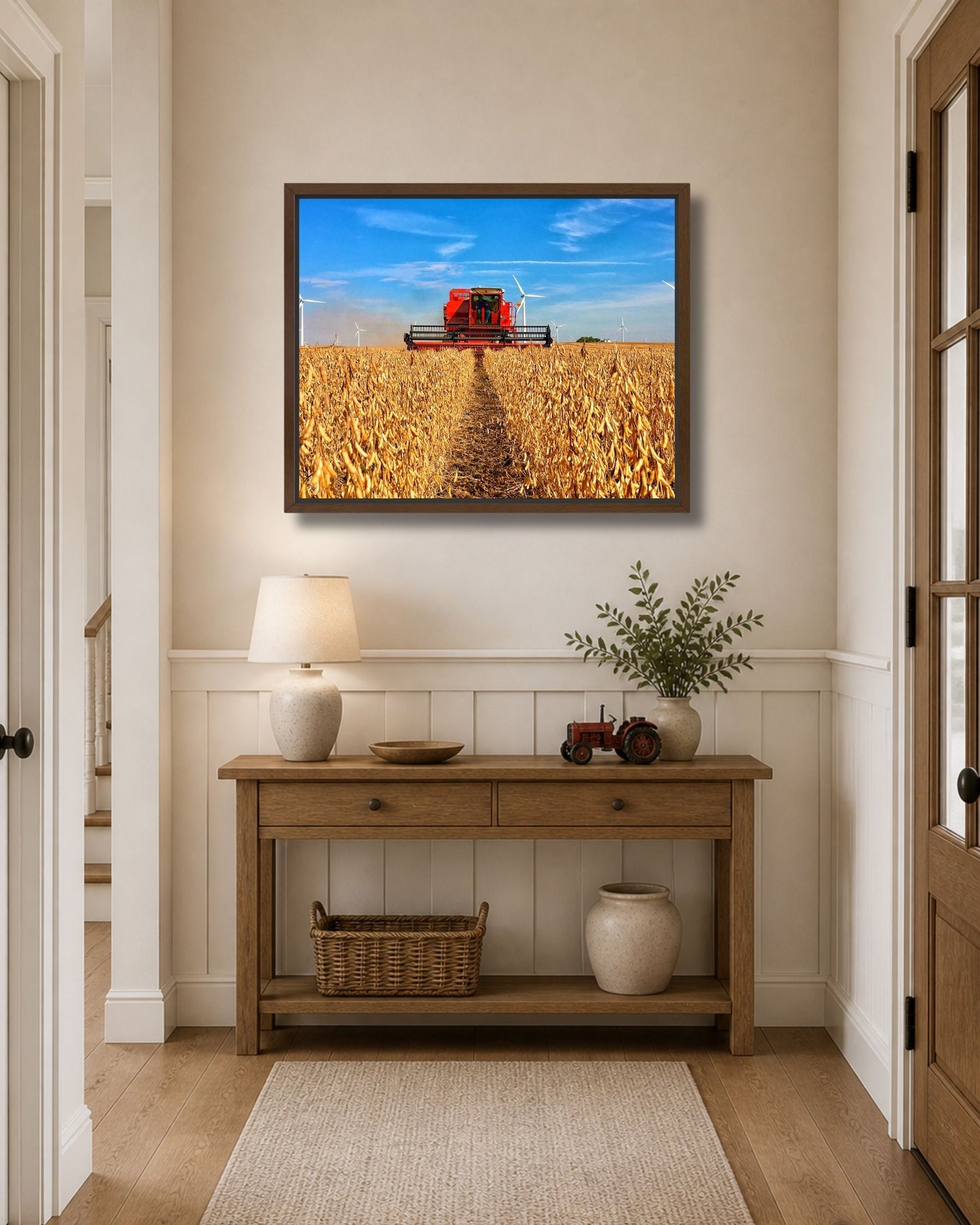 Walnut framed combine harvest wall art styled above an entryway console table with warm farmhouse decor.