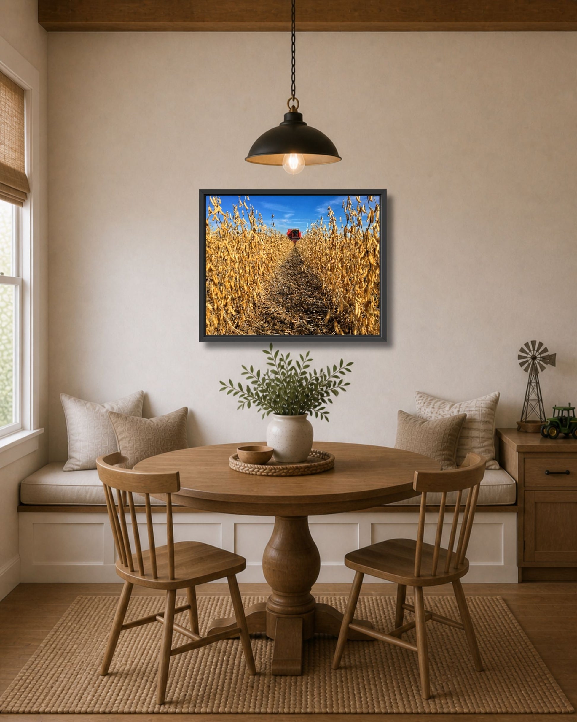 Black framed soybean harvest wall art displayed above a breakfast nook table in a warm modern farmhouse interior.