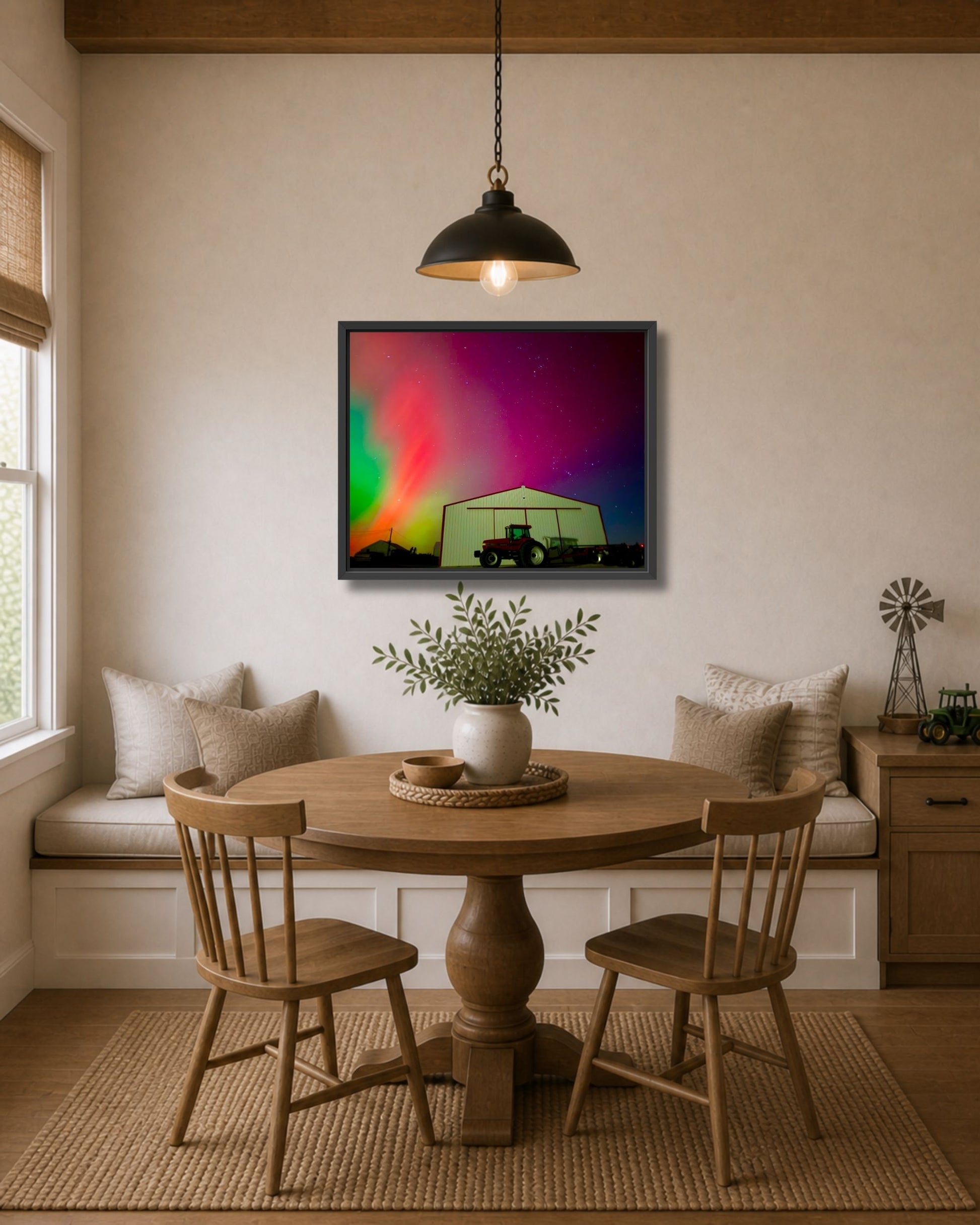 Black framed northern lights farm wall art displayed above a breakfast nook table in a warm modern farmhouse interior.